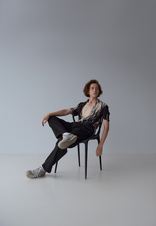 woman in black shirt and white pants sitting on white seat