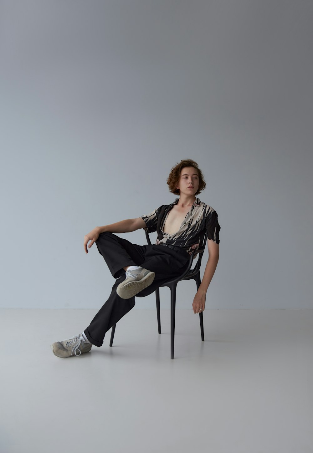 woman in black shirt and white pants sitting on white seat