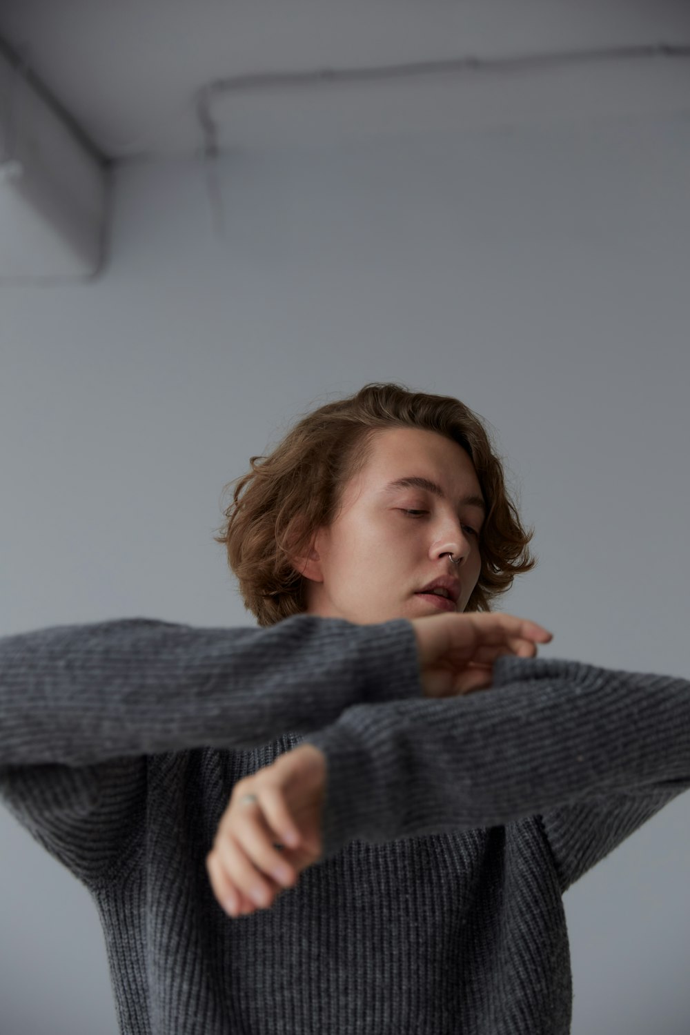 girl in gray sweater covering her face with her hand