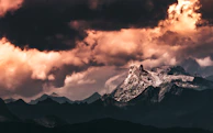 Wide shot of a mountain range under dramatic storm clouds.