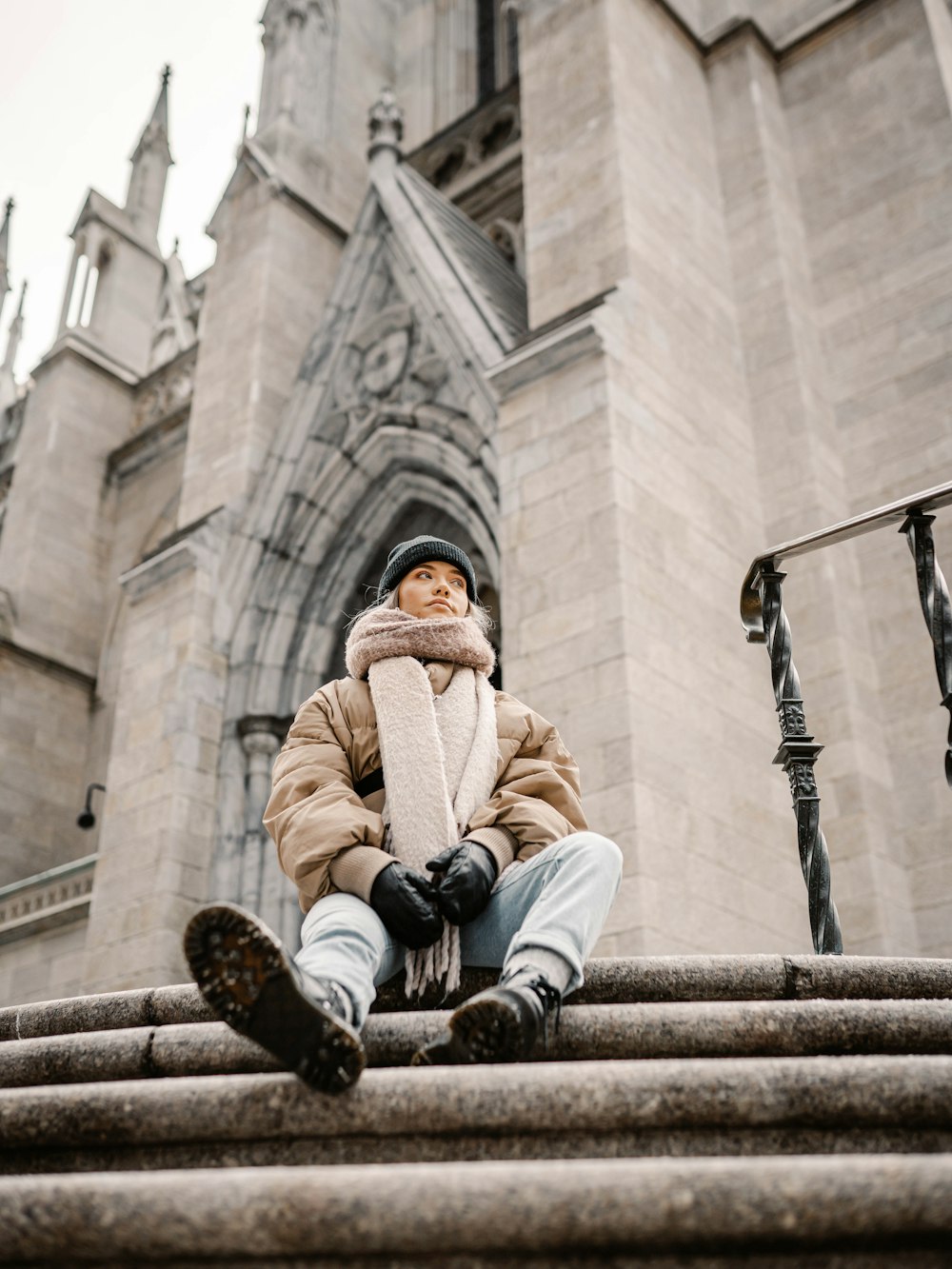 man in brown coat sitting on concrete bench