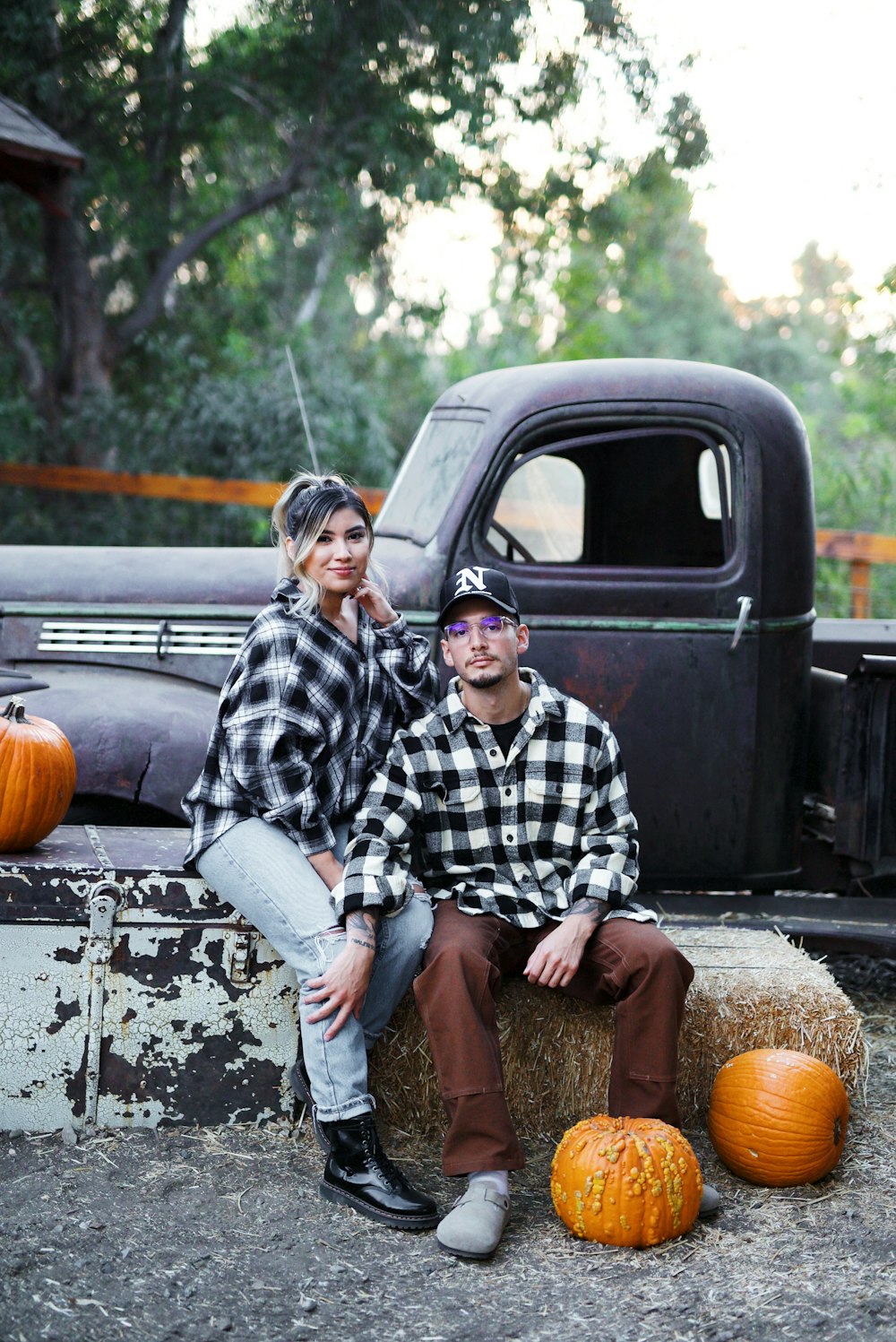 man in black and white checkered dress shirt sitting on black truck during daytime