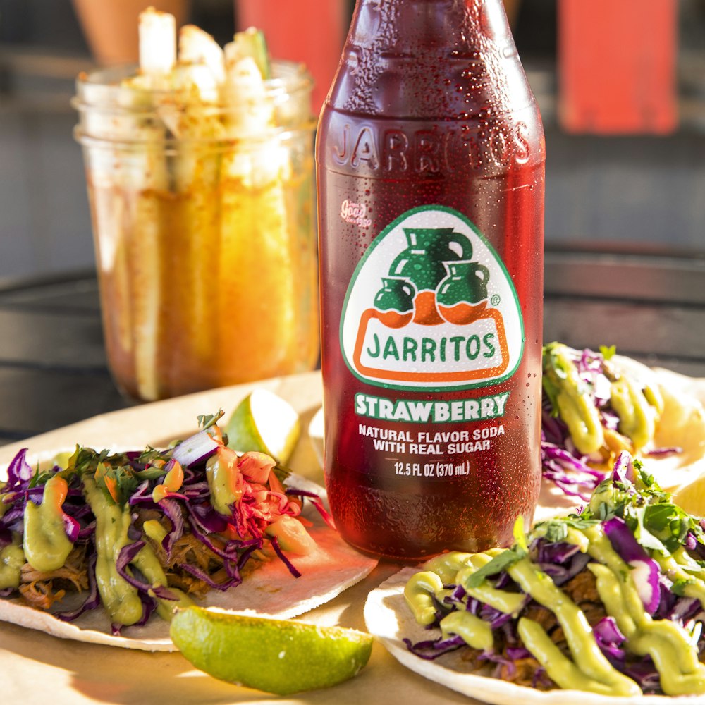 a bottle of juice sitting next to a plate of food