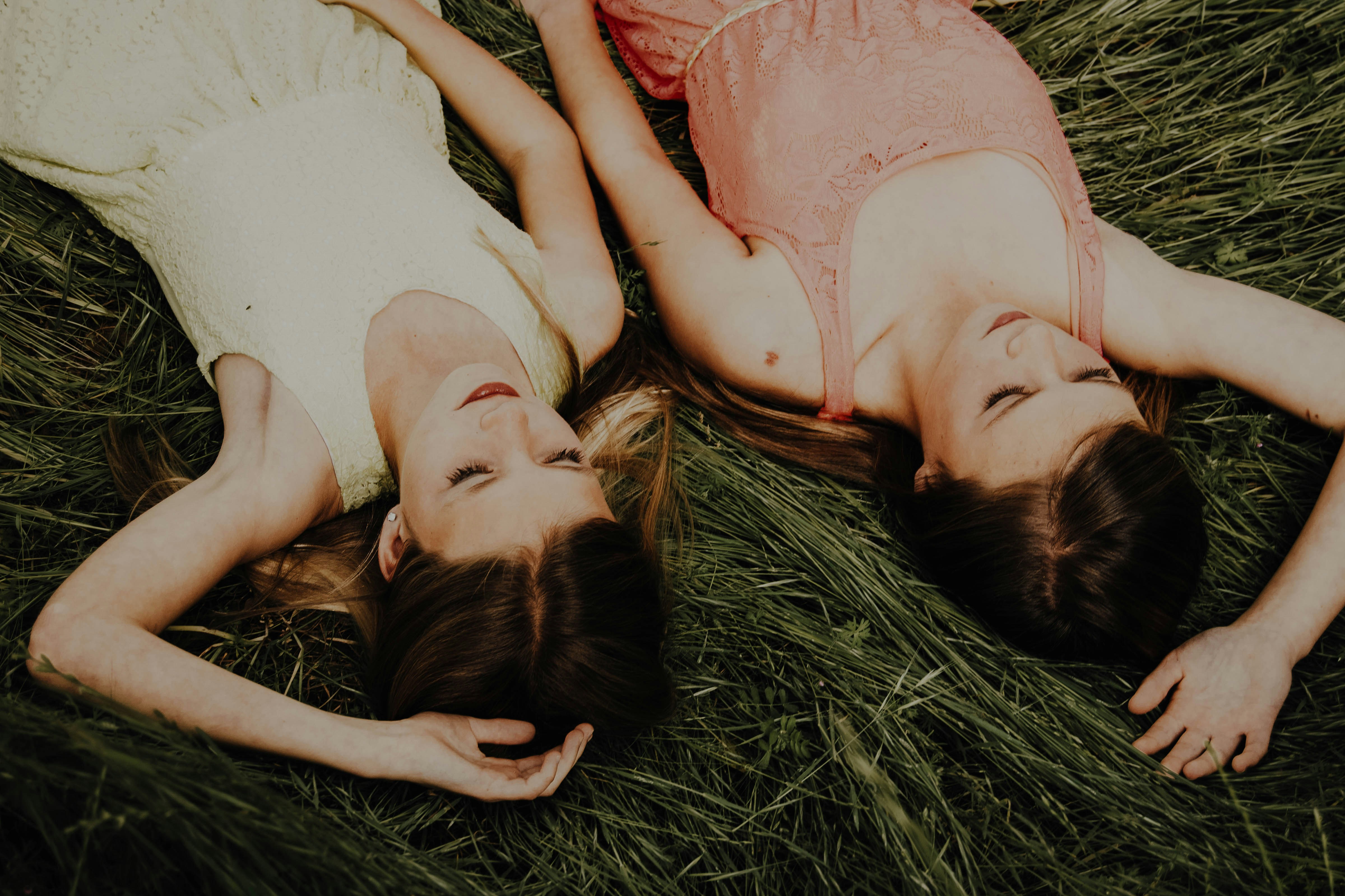 woman in pink tank top lying on green grass
