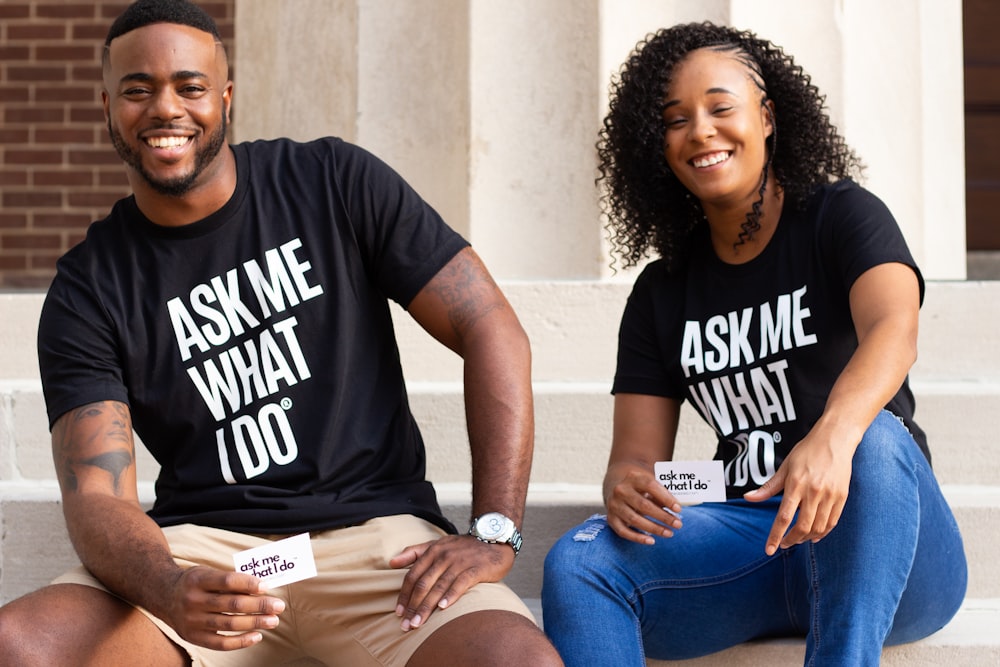 man in black crew neck t-shirt sitting beside woman in blue denim jeans