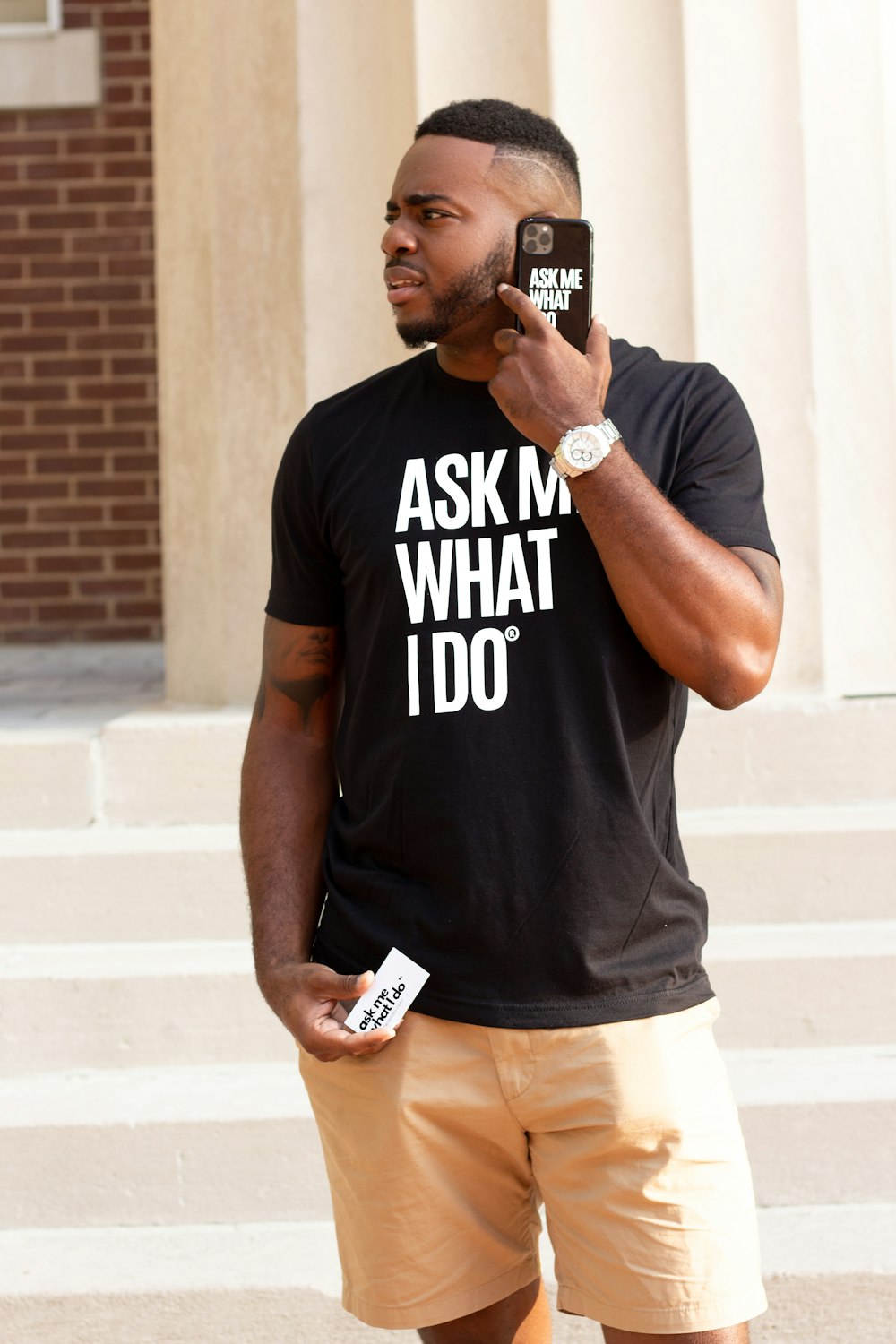 man in black crew neck t-shirt and white shorts standing and smiling