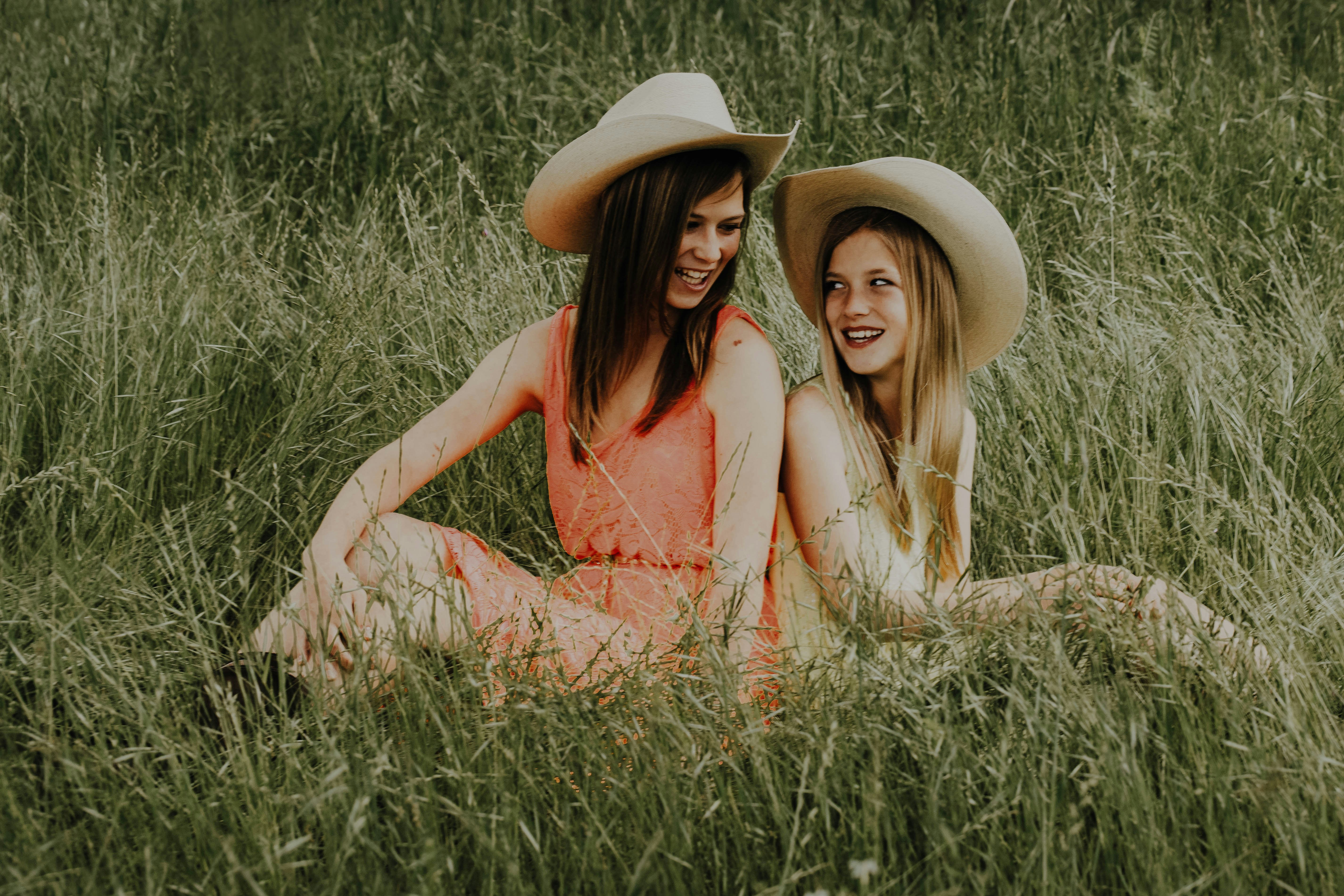 woman in brown dress sitting on brown grass