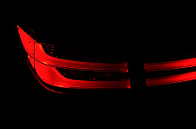 A close-up of sleek LED car lights glowing vividly in a dim garage.