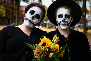 woman in black shirt wearing white mask holding yellow flowers