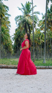 Elegant woman in a flowing dress walking along a sunlit Palm Beach promenade at golden hour.