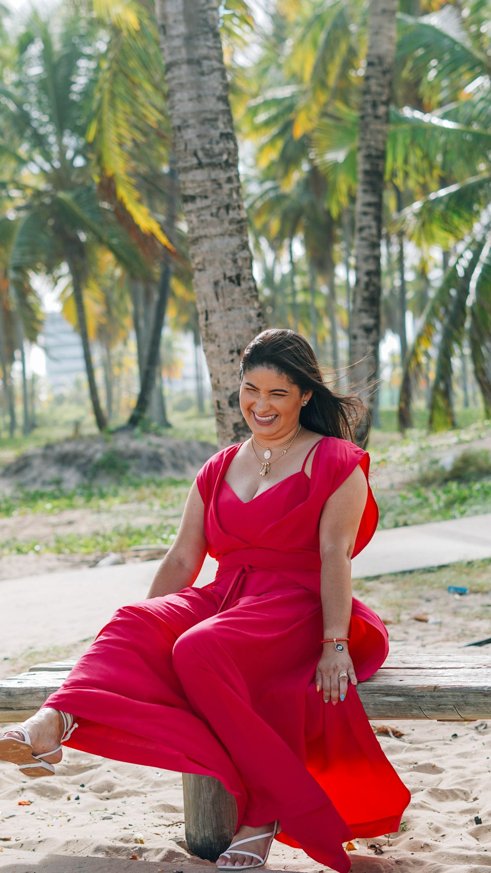 woman in red tank top and red pants sitting on red plastic basin during daytime