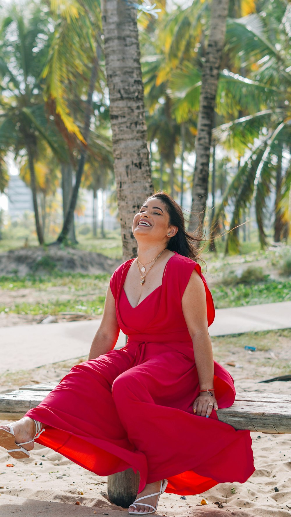 woman in red tank top and red pants sitting on ground during daytime