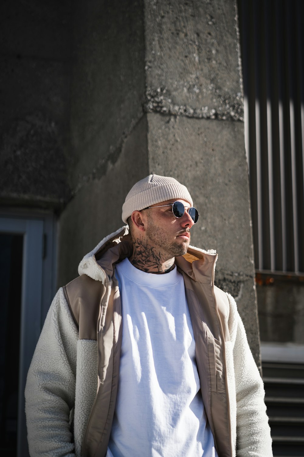 man in white knit cap and brown coat smoking cigarette