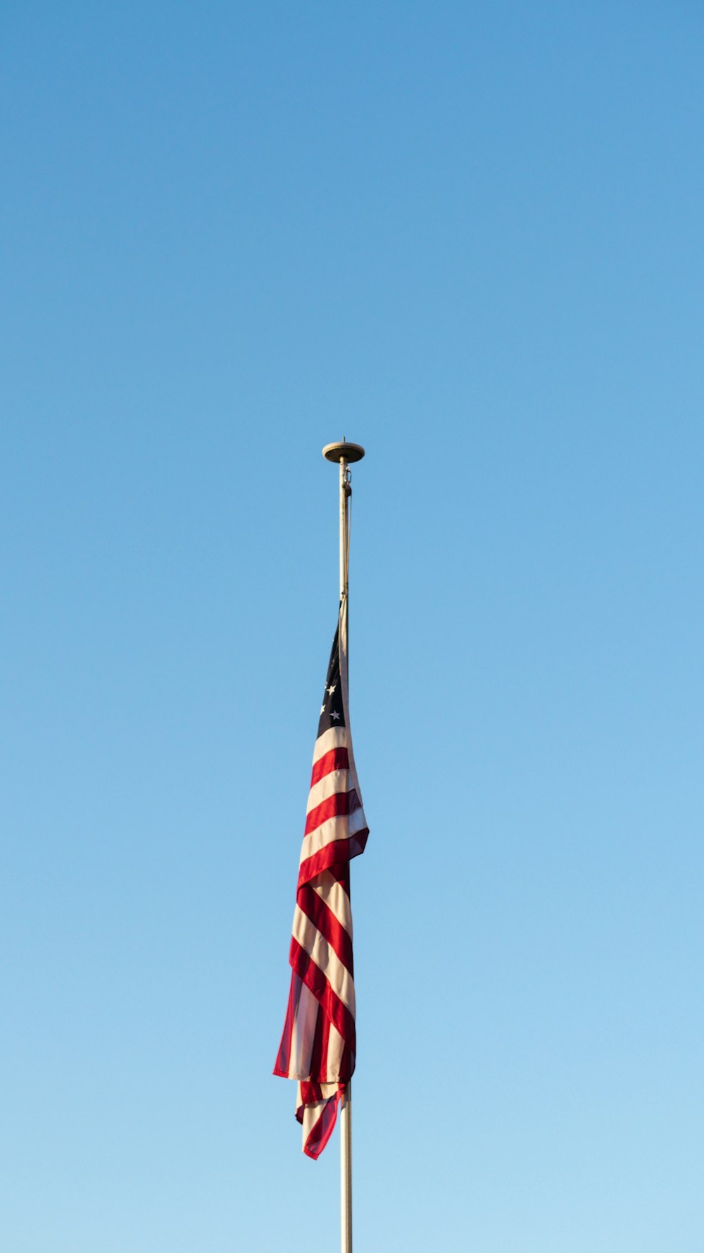 flag of us a on pole under blue sky during daytime