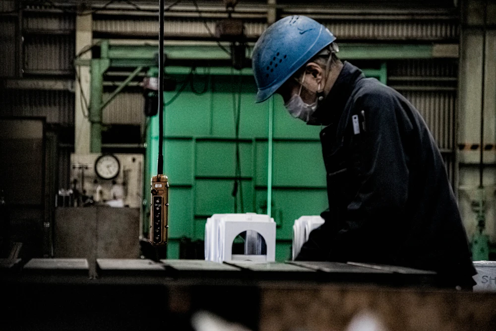 Welder in a blue cap working in a workshop – one of the skilled trades FINAS recruits for