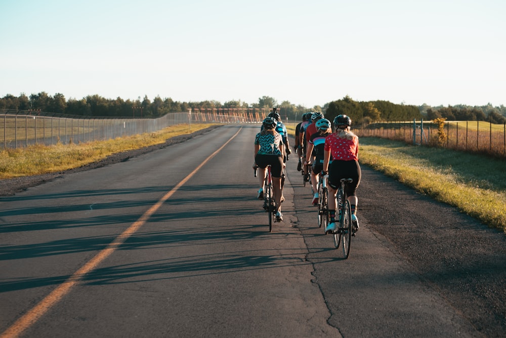 people riding bicycle on road during daytime