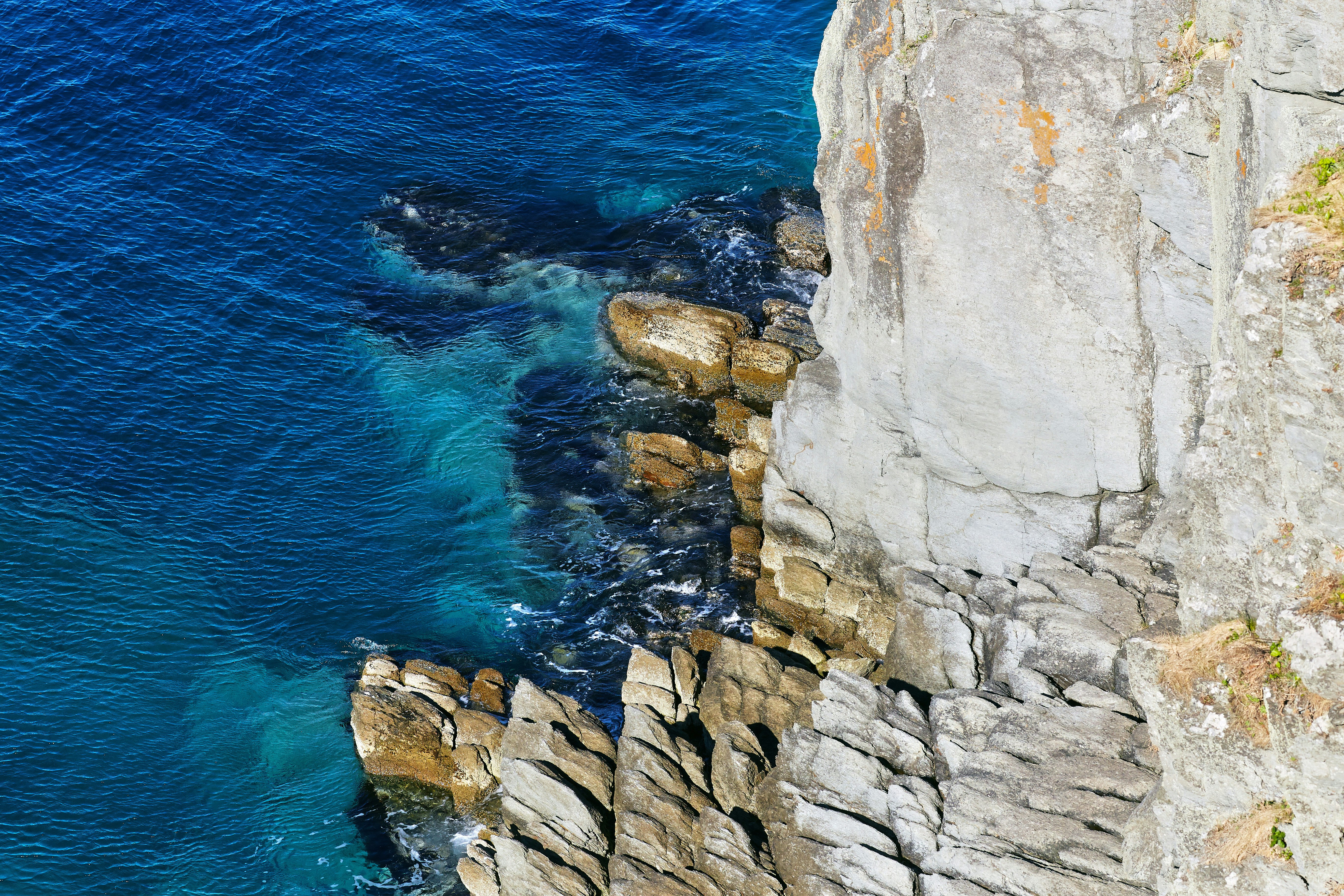 gray rock formation beside blue sea during daytime