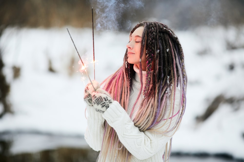 woman in white long sleeve shirt holding white powder