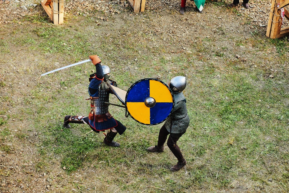 homme en costume noir et rouge tenant une épée