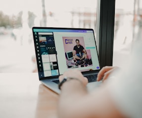 person using macbook pro on brown wooden table