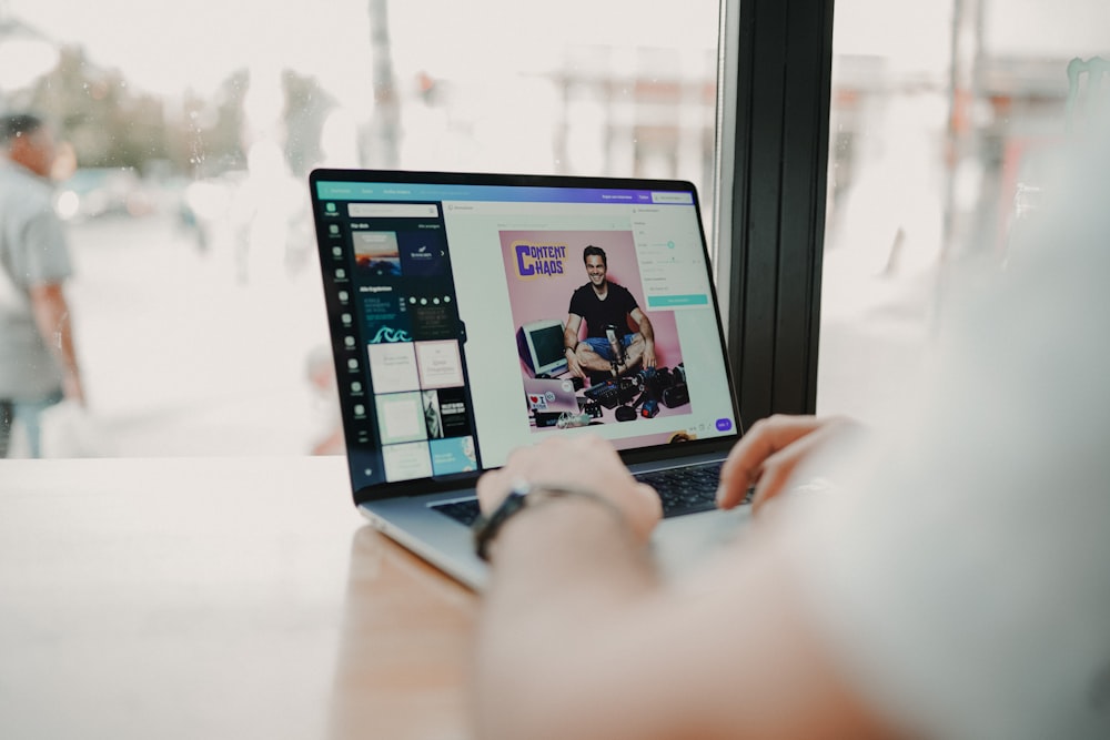 person using macbook pro on brown wooden table