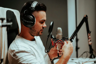 Close-up of Owen Alexander in a cozy studio, headphones on, deeply immersed in recording.