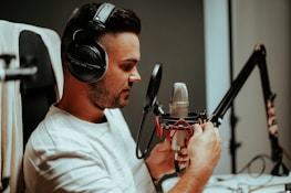 Artist wearing headphones, focused while recording vocals in the studio.