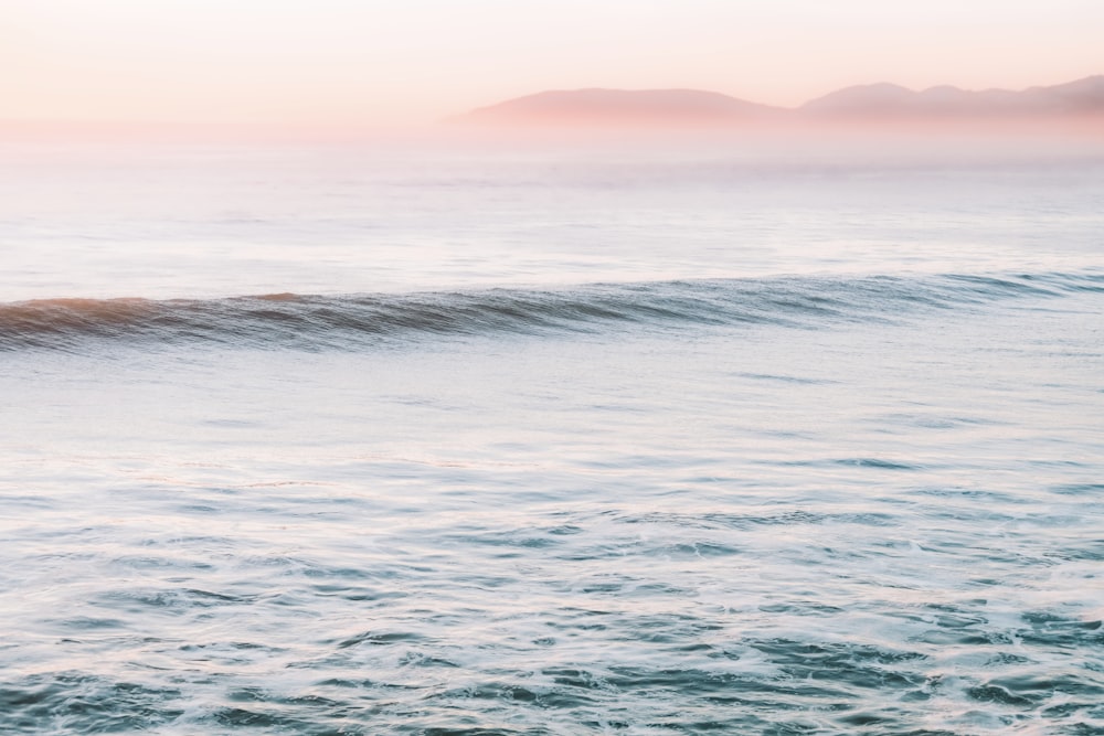 ocean waves under cloudy sky during daytime