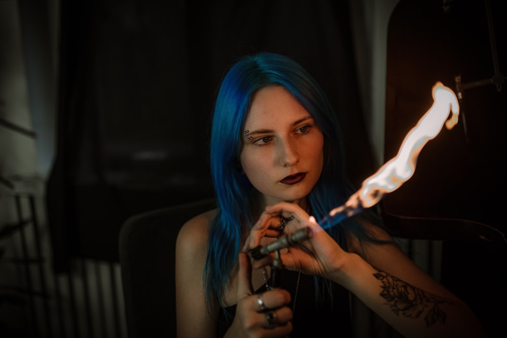 woman with blue hair holding cigarette stick