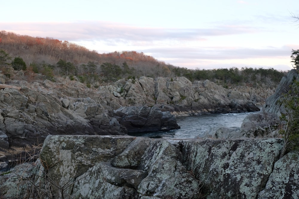 rocky mountain beside body of water during daytime