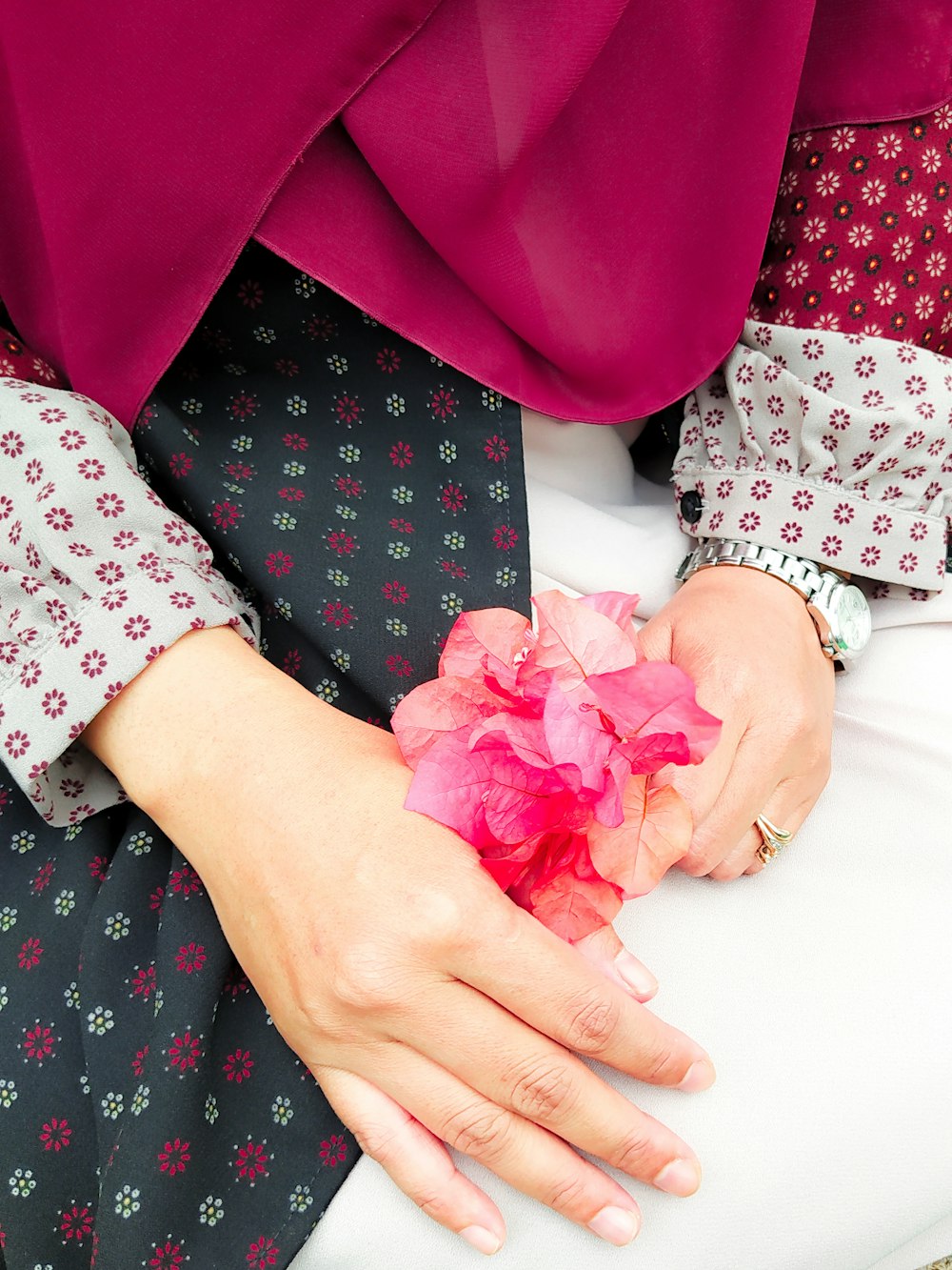 person holding pink flower petals