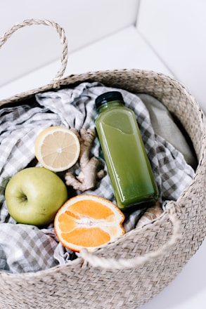green disposable lighter beside orange fruit on brown woven basket