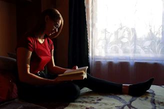 woman in red tank top reading book