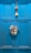 A bright blue wooden door is adorned with a colorful painter's palette and a decorative hanging, which includes a small bell and beads.