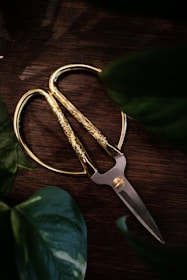 silver scissors on brown wooden table