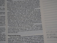 A close-up photo of an open book with handwritten philosophical notes and sketches.