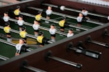 A row of professional foosball tables lined up in a sports facility.