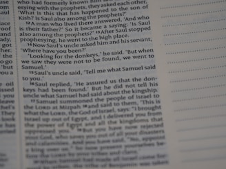 A close-up view of a page from a religious text appears, with text in English discussing biblical events involving Saul. On the right, there is a column of dotted empty lines, suggesting space for notes.