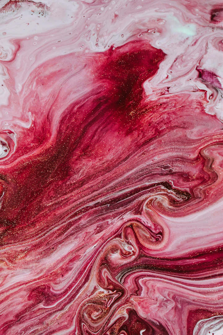 Abstract fluid painting with swirls of red, pink, and white paint and gold glitter