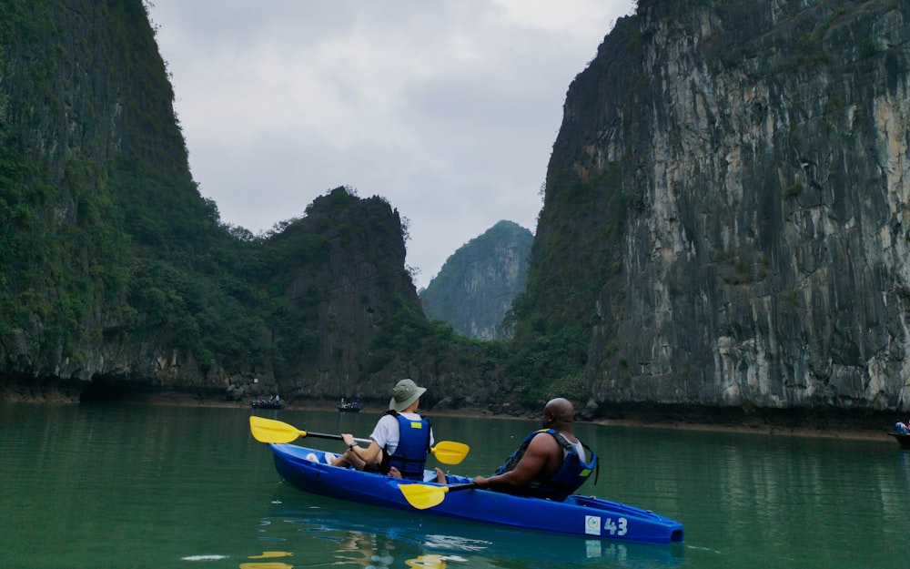 man in blue life vest riding blue kayak on river during daytime