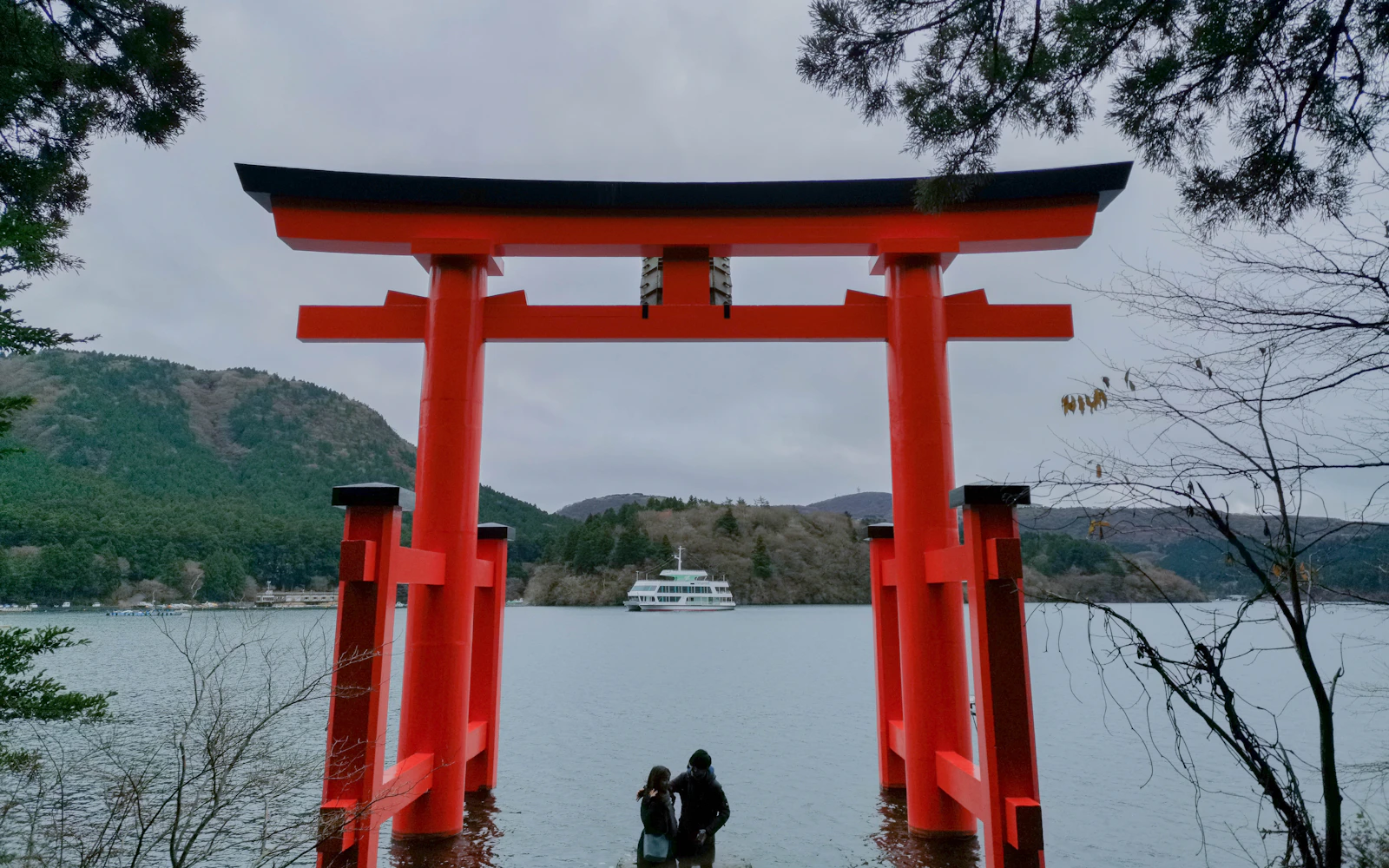 A red torii gate beside calm water
