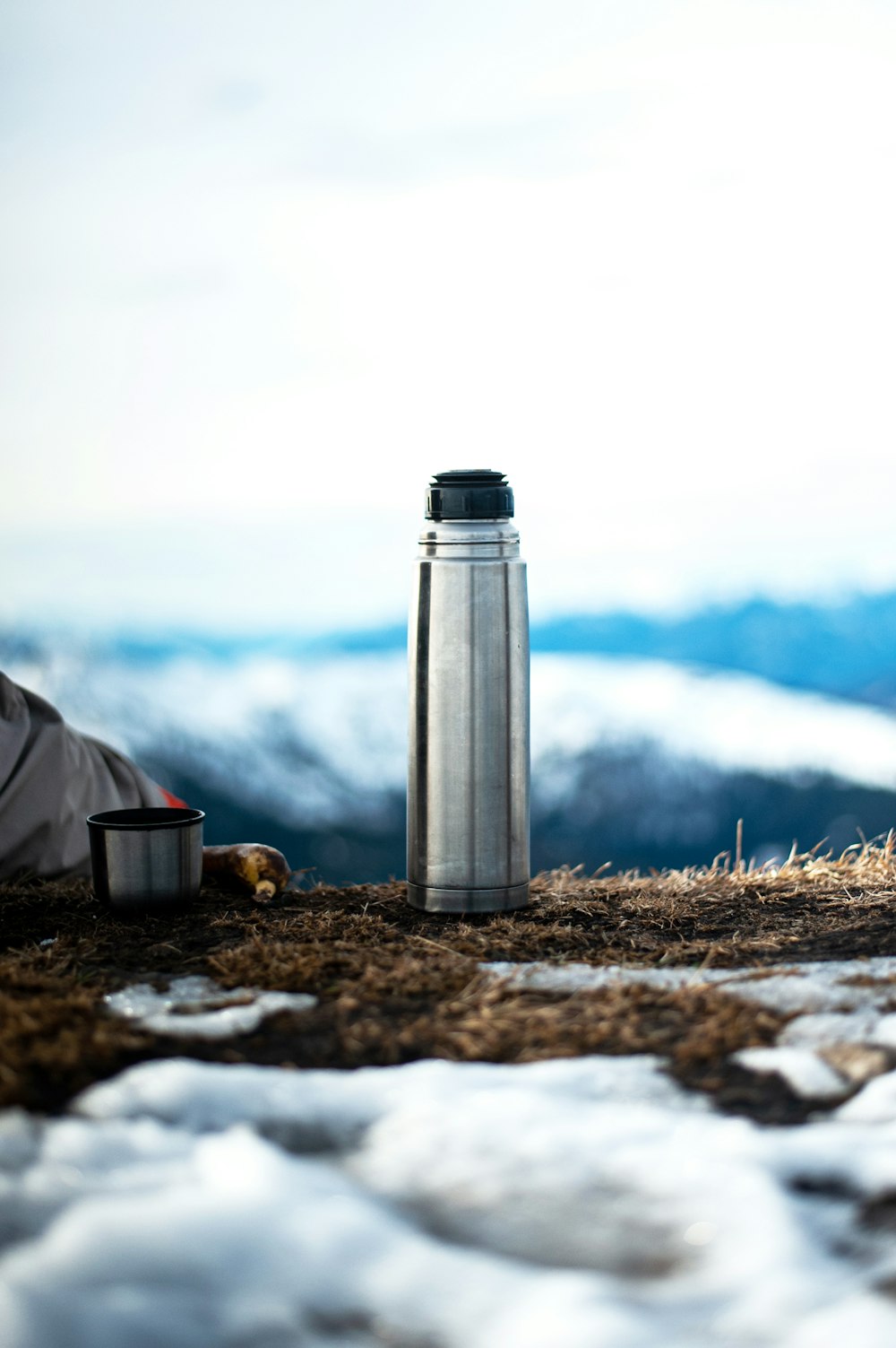 Silber-Isolierflasche auf braunem getrocknetem Gras