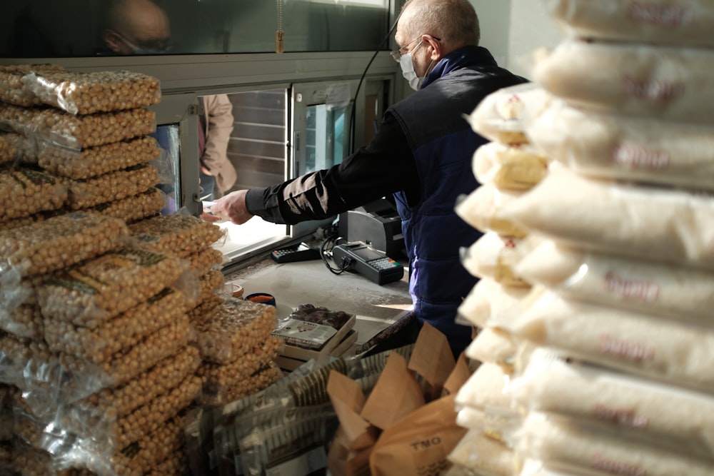 man in black long sleeve shirt holding brown bread