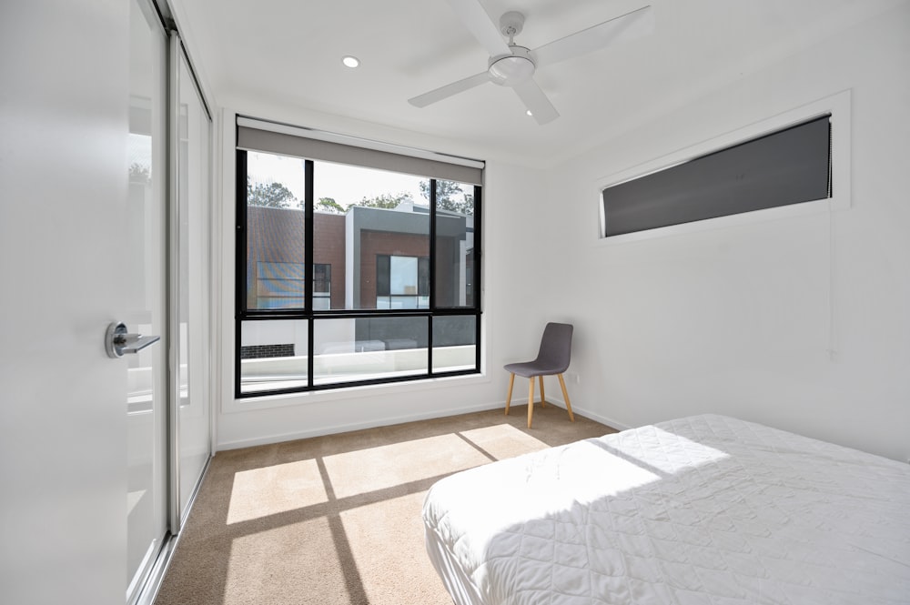 white bed near black framed glass window