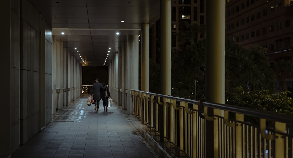 man in black jacket walking on hallway