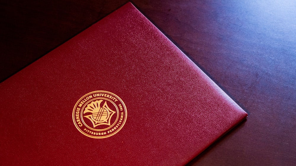 red and gold book on black textile