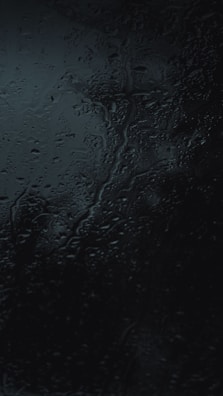 A close-up of water droplets sliding off a freshly cleaned window.