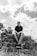 man in black t-shirt sitting on rock
