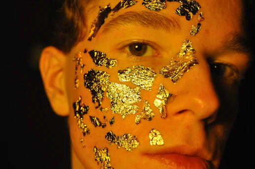 person with gold and silver floral face paint