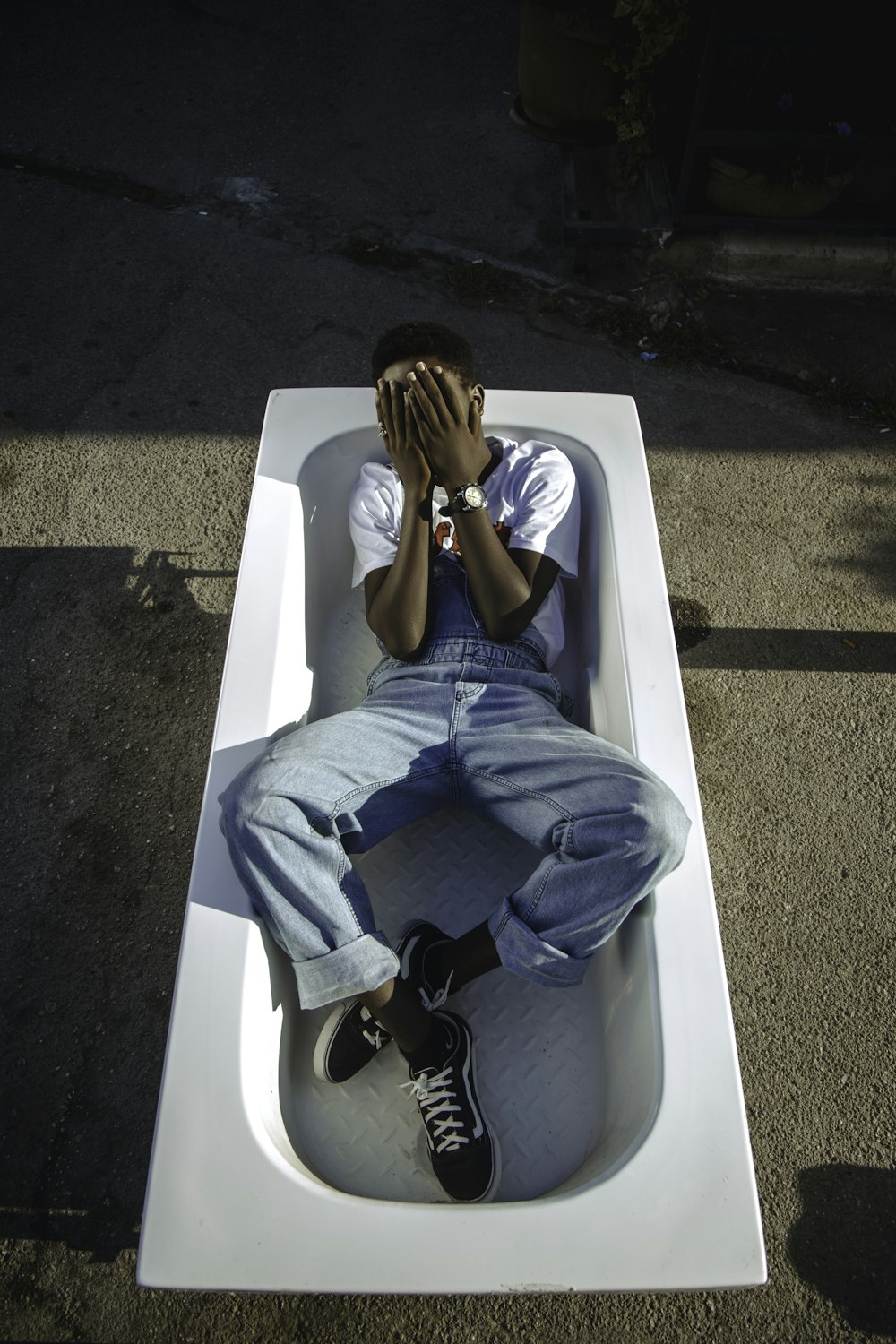 man in blue denim jeans sitting on white ceramic bathtub